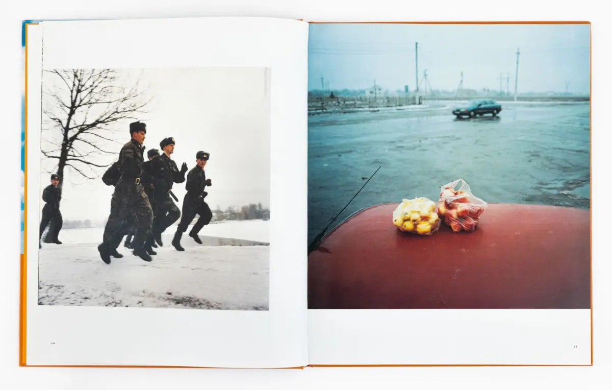 Open book showing two photos: left, soldiers in winter camouflage marching in snow; right, car on a wet road with bags of fruit on its hood.
