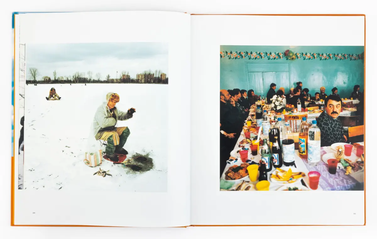 Open book showing left: person ice-fishing on snowy lake, distant trees and buildings; right: banquet with guests at long table in a decorated room.