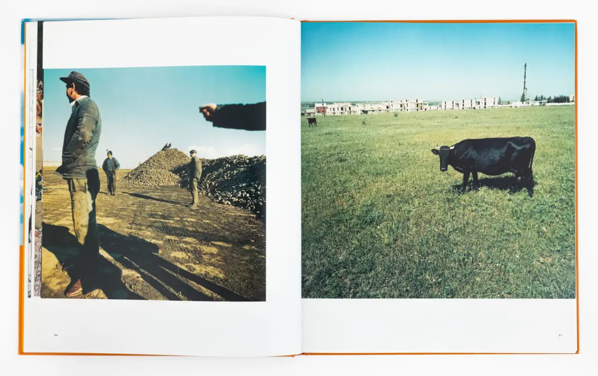 Two-page spread: left shows workers at a gravel site with a rock pile; right shows a black cow grazing in a green field with distant buildings.