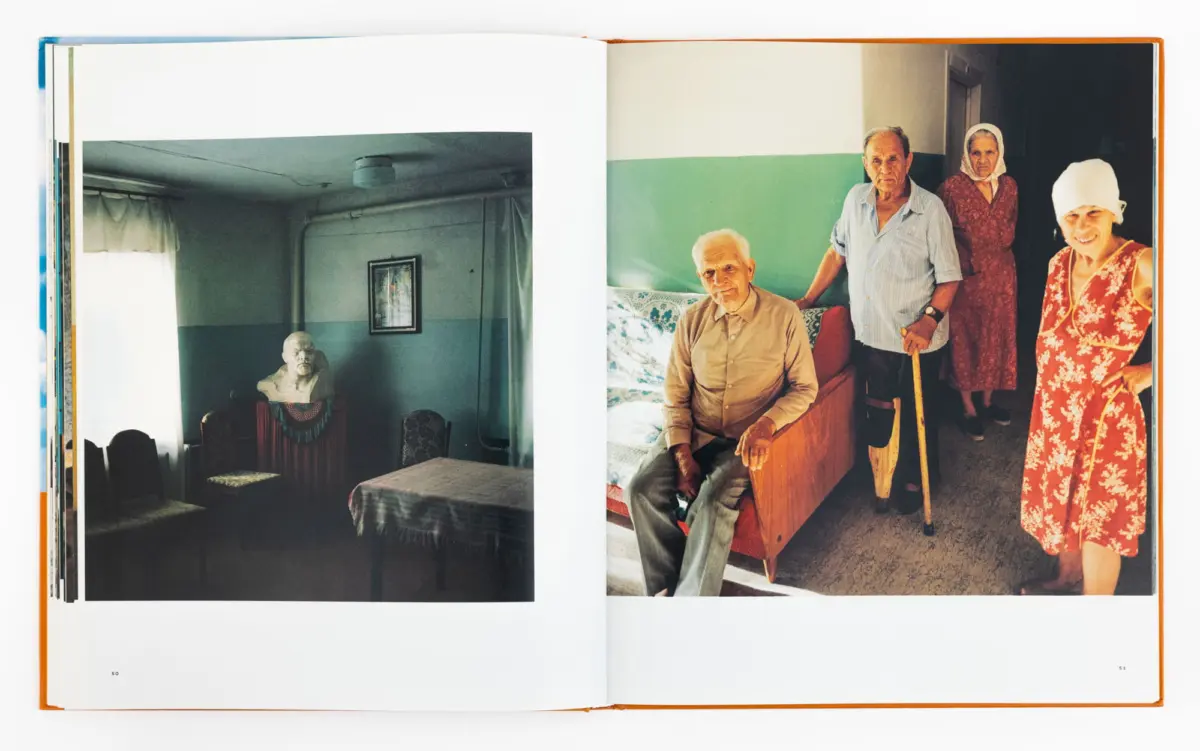 Open book spread; left page shows a dim room with a bust on a table; right page four elderly people pose in a green-walled living room.
