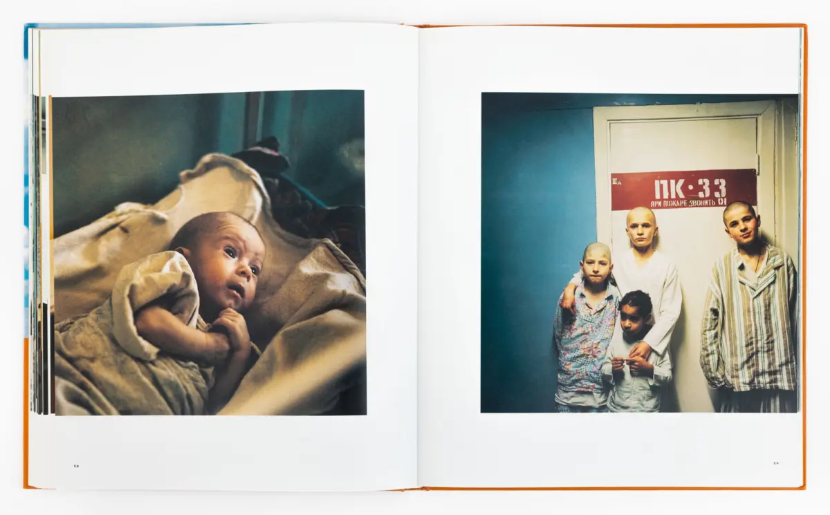 Open book with two photos: left, infant lying in bed under blankets; right, group of youths posing by a door with a red sign.