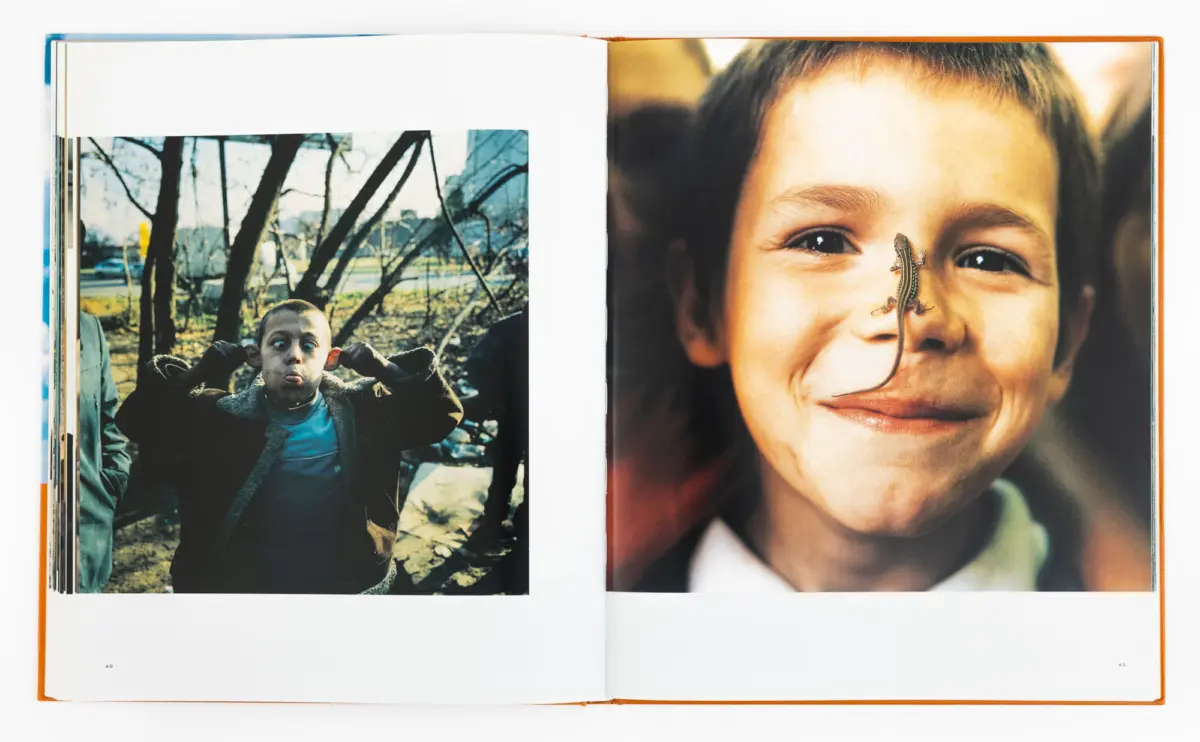 Two-page photo spread: left shows a boy making a funny face outdoors; right shows a close-up of a smiling boy with a lizard on his nose.