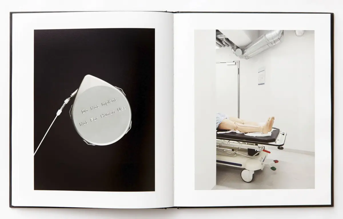 Open book with two pages: left shows a circular medical device with 'Do Not Implant Not For Human Use' on black; right shows a hospital room with a patient on a wheeled stretcher.