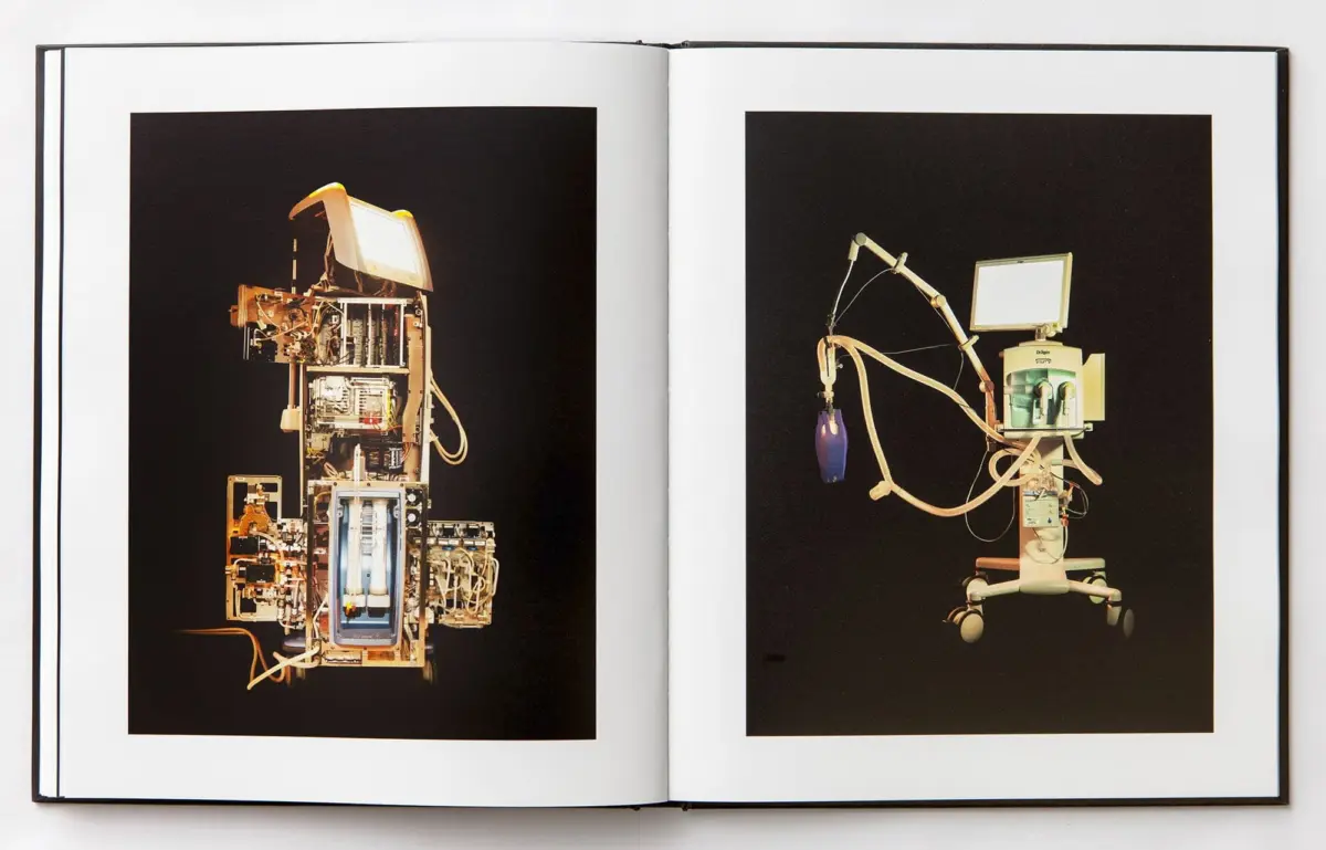 Two-page spread of medical robotics against black background; left shows a tall modular device, right a wheeled robot with a monitor.