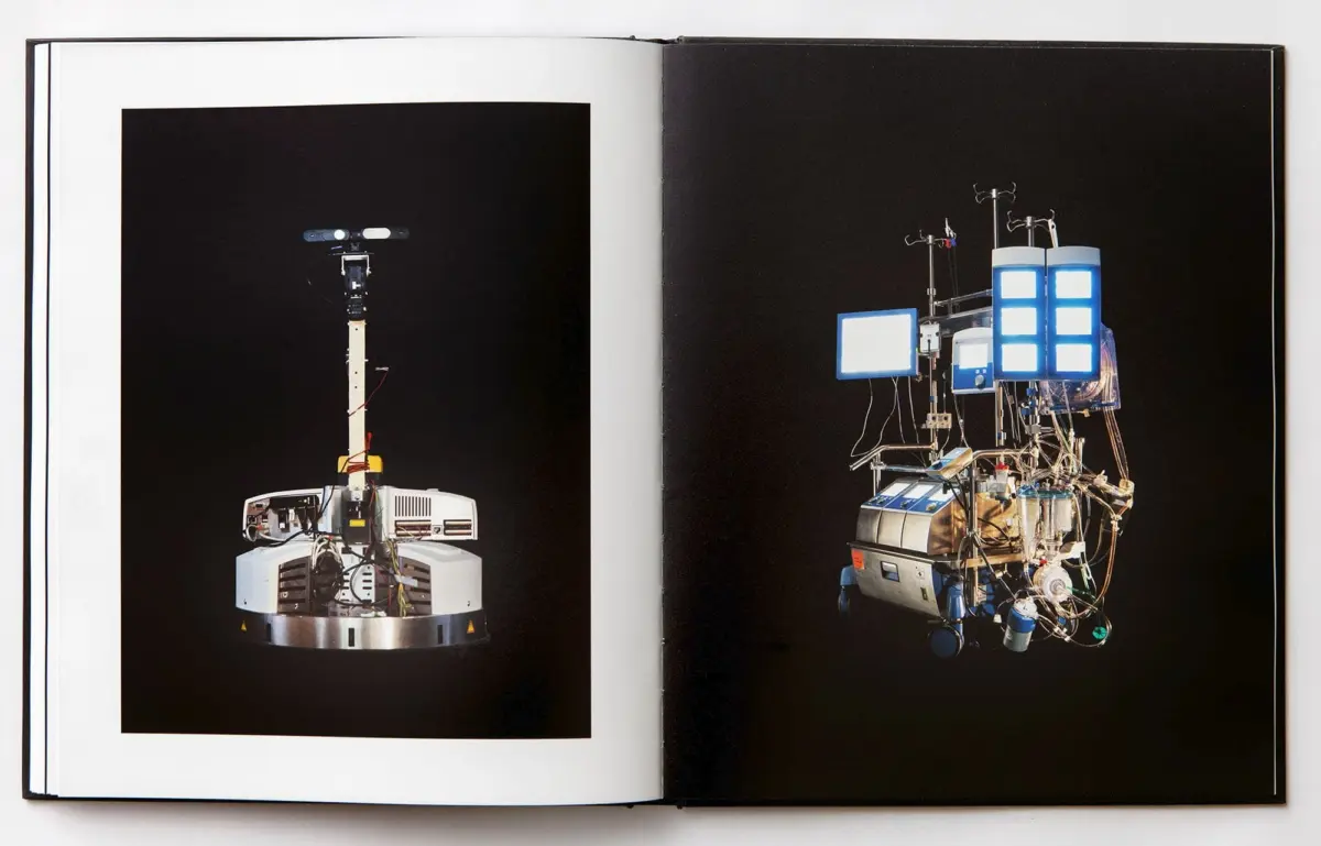 Open book spread: left a tall robotic arm on a circular base; right a complex modular apparatus with blue screens.