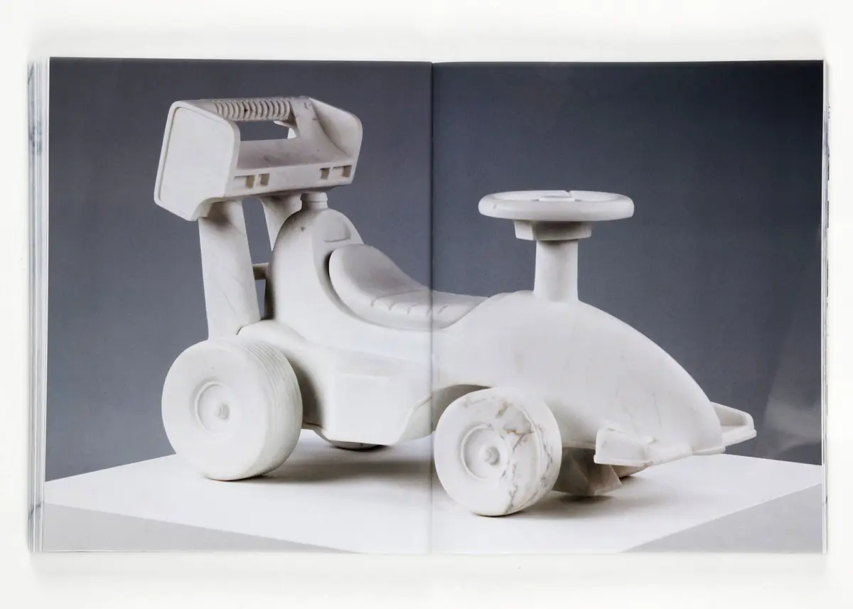 White plastic toy tractor with large wheels on a two-page book spread.