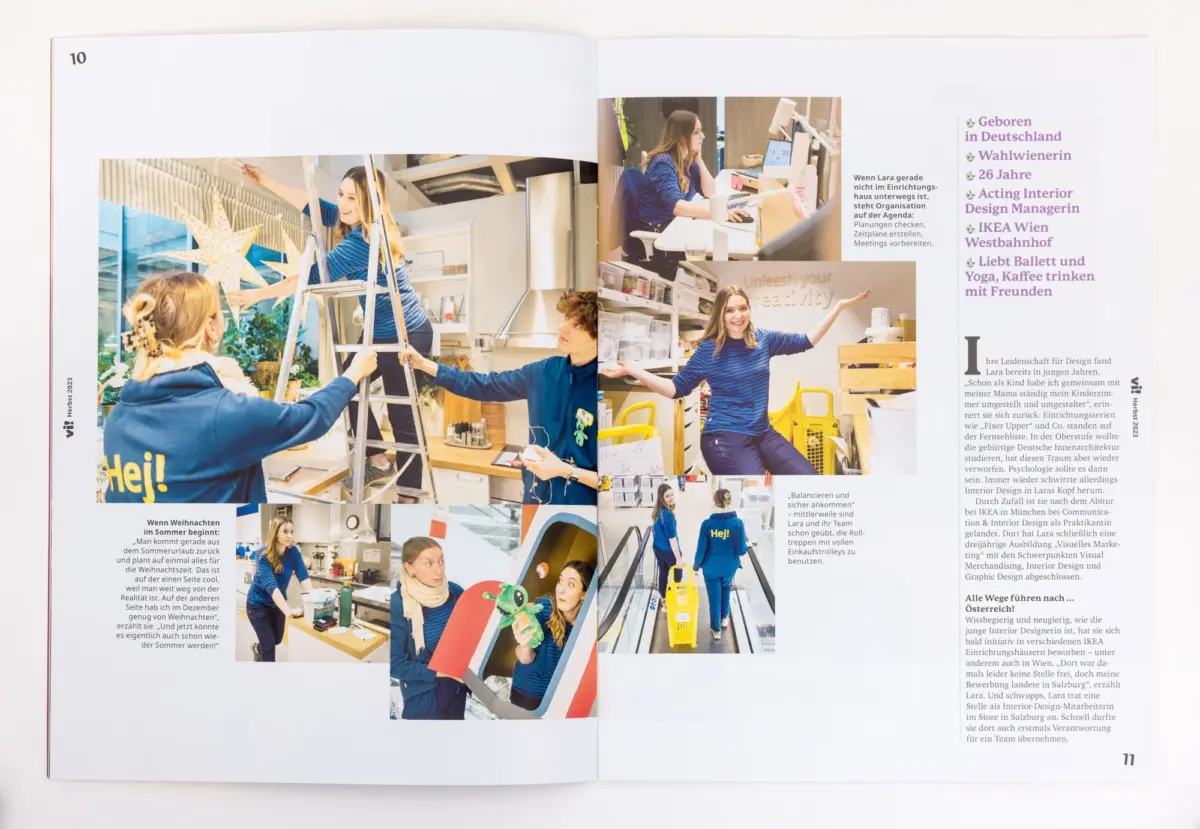 Team members in blue-striped shirts assemble holiday decorations in a bright design studio, using a ladder and desks.
