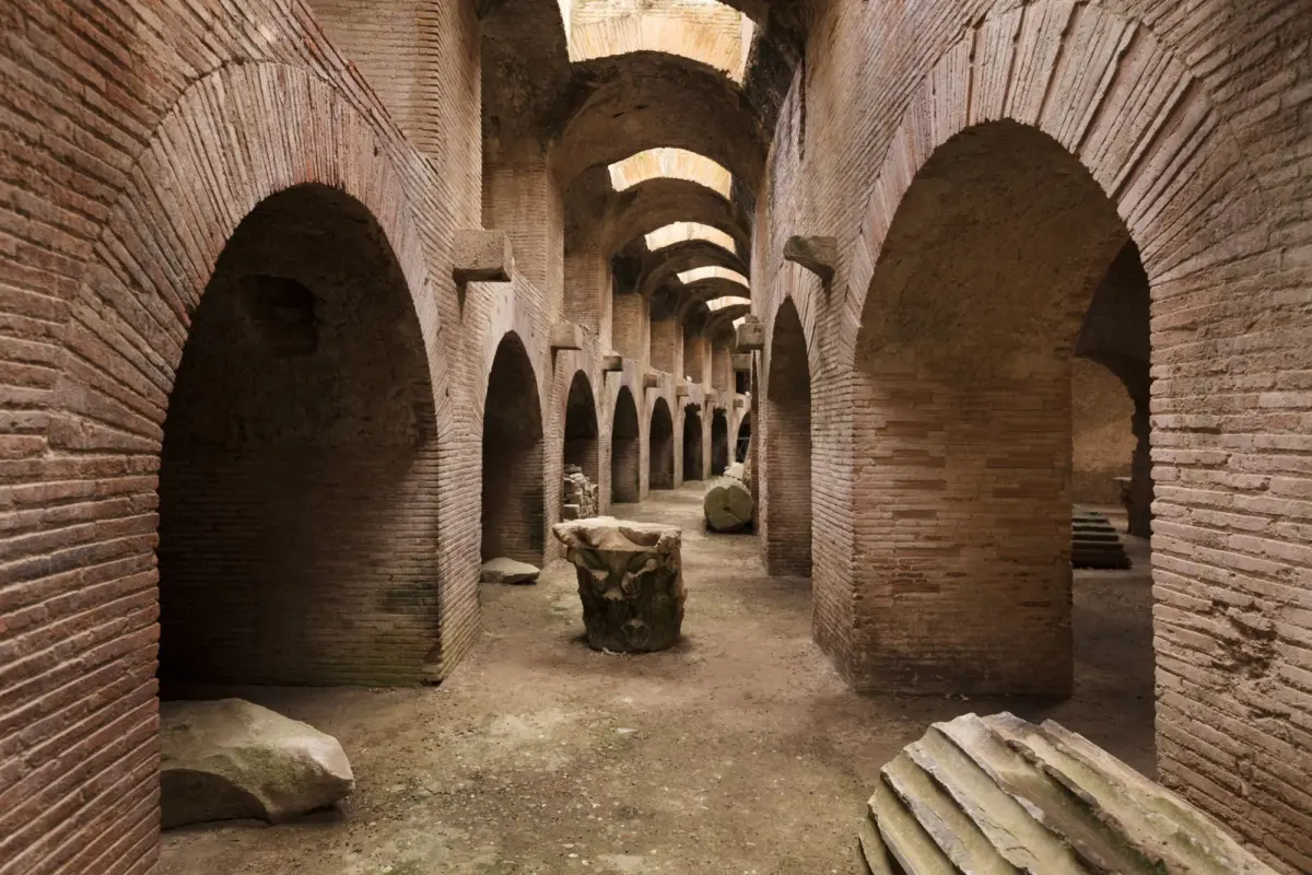 Ancient brick arch colonnade forming a long passage with evenly spaced rounded arches and stone columns in a desert ruin.