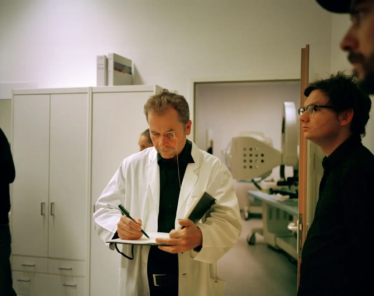 Scientist in a white lab coat writes on a clipboard in a clinical laboratory with white cabinets