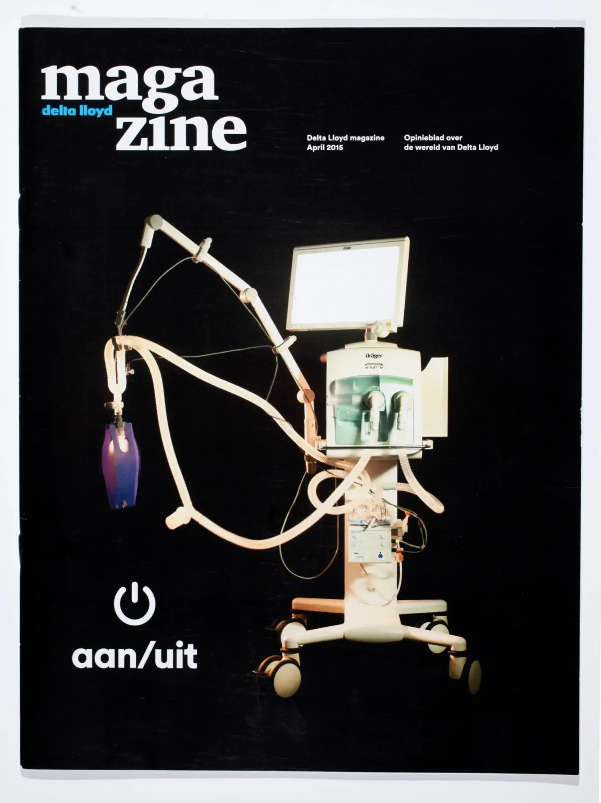Medical device with monitor and tubing on a wheeled stand against a black background; magazine cover design.