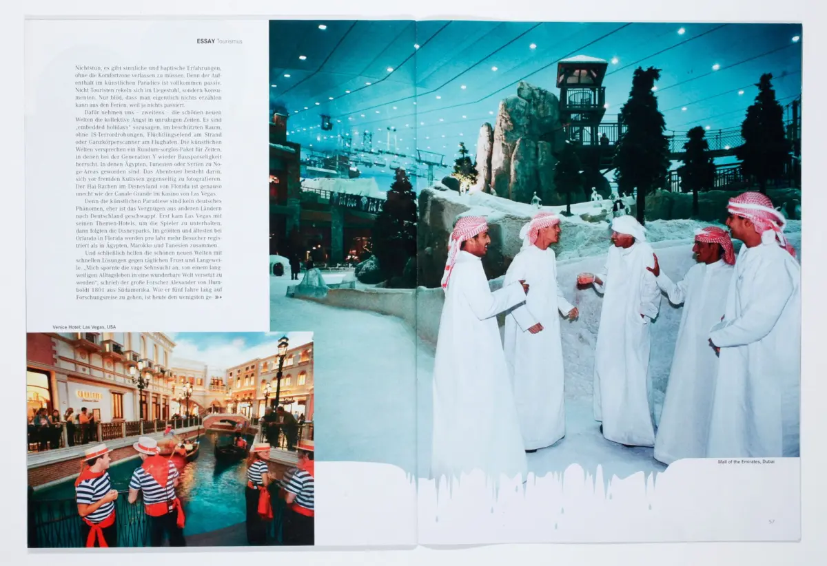 Group of Arab men in white kanduras converse on a snowy indoor landscape with rock formations and a ski lift.