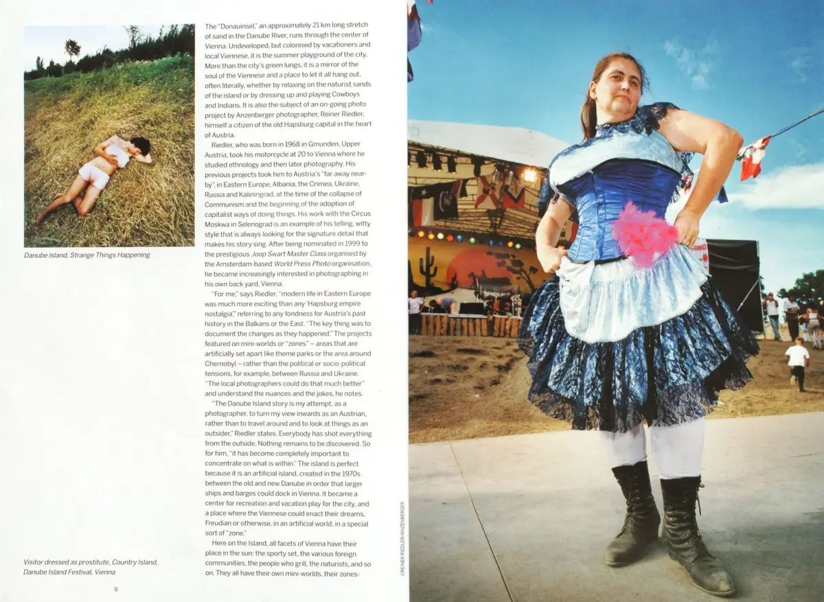 Woman in a blue Victorian-style dress dances on an outdoor Danube Island festival stage under a clear blue sky.