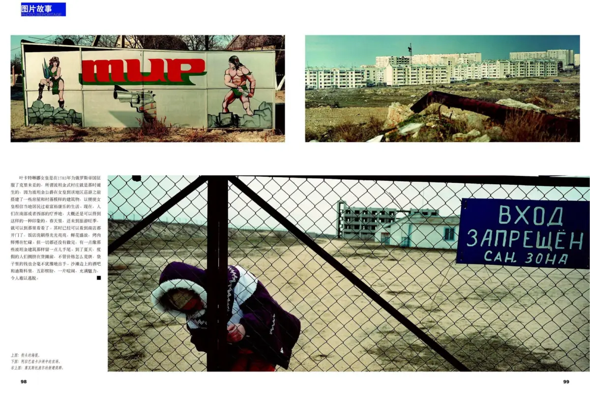 Graffiti mural of a muscular male fighter and a female warrior on a wall in a barren lot; background shows apartment blocks and a chain-link fence.