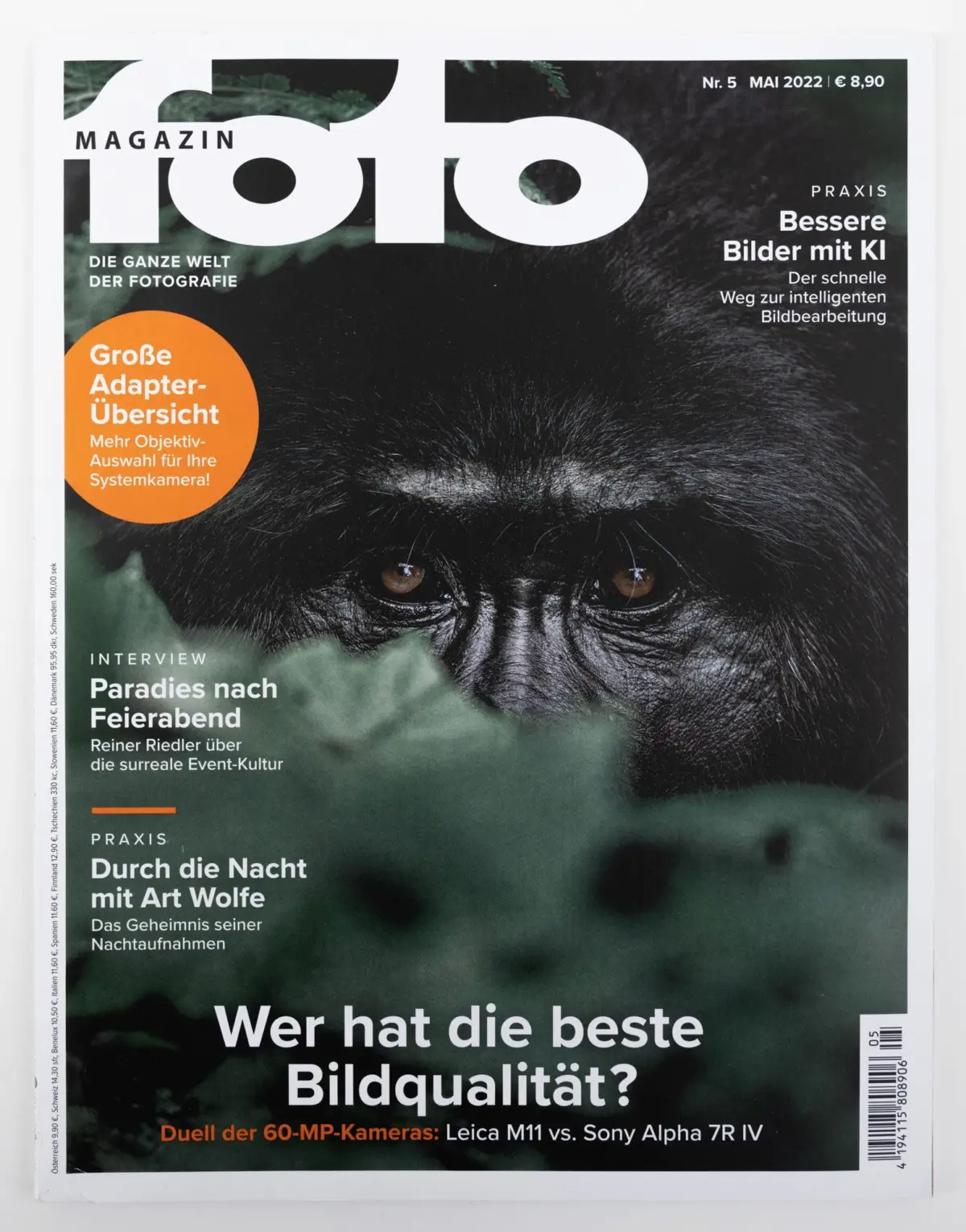 Close-up of a chimpanzee face on a magazine cover with bold white typography and an orange circular graphic.