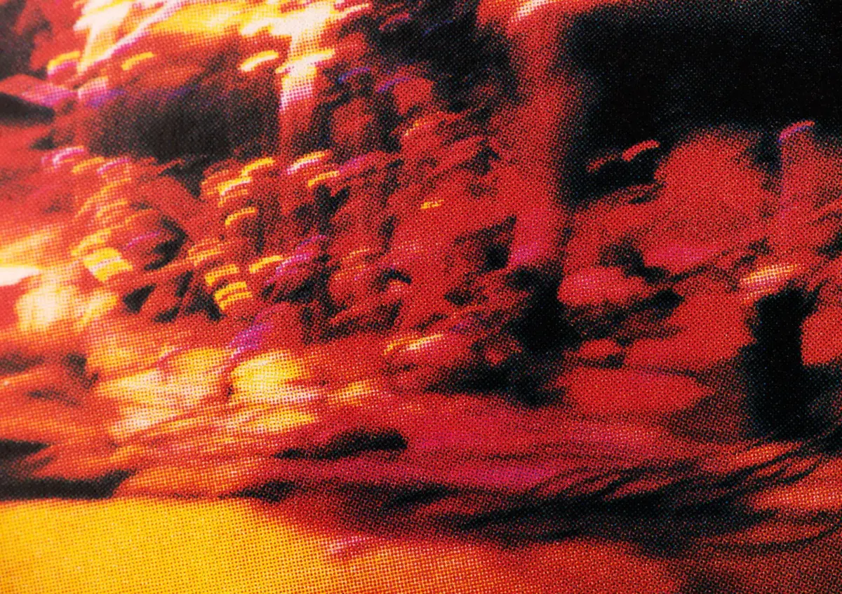 Close-up of red-orange halftone print texture with dark shadows; abstract pattern.