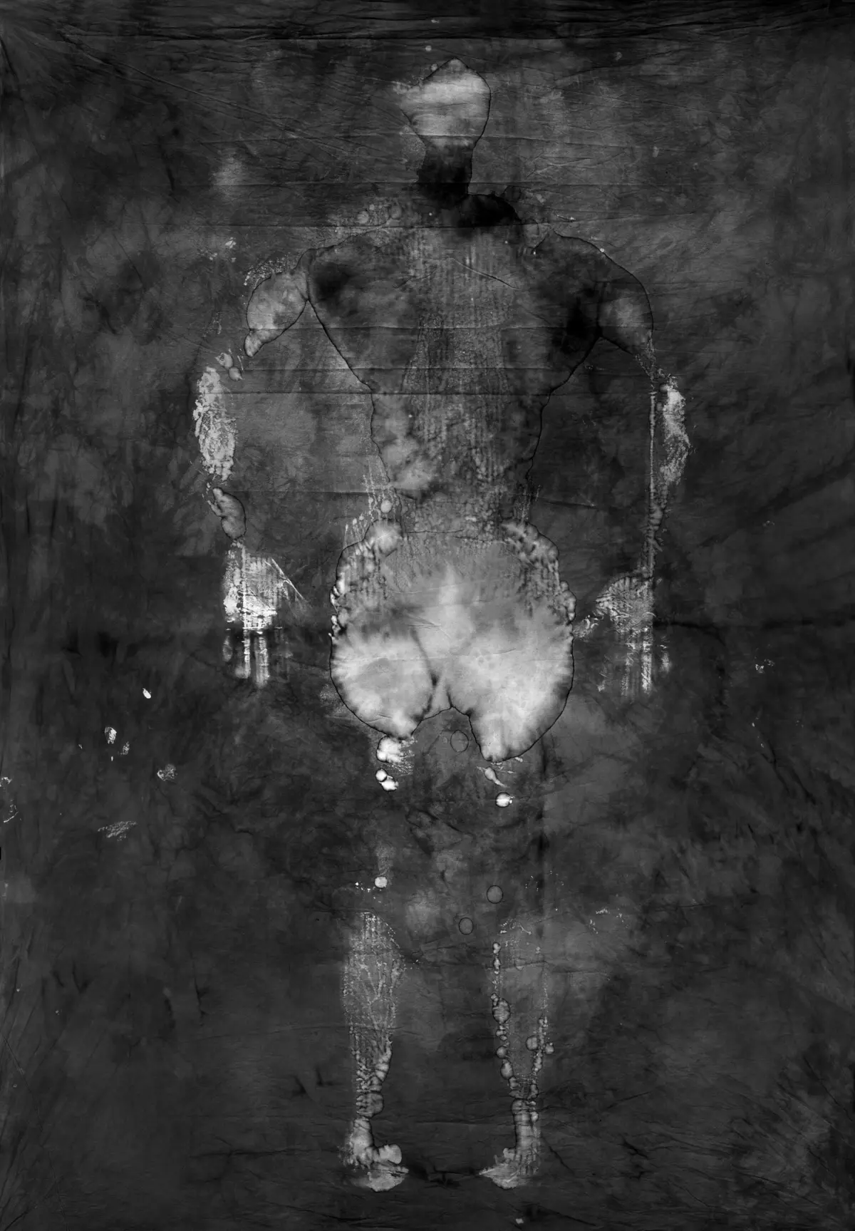 Back-facing human silhouette standing against a dark, textured backdrop.