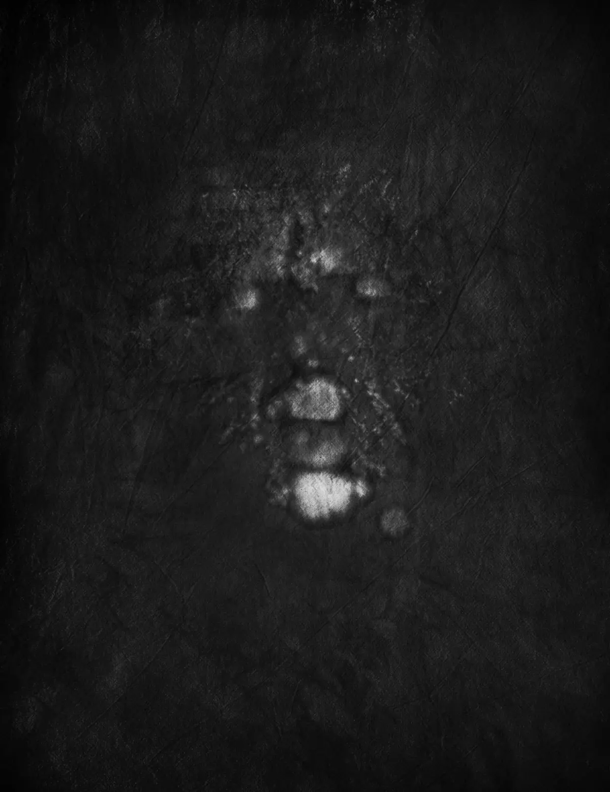 Vertical row of glowing white circles on a dark, textured surface.