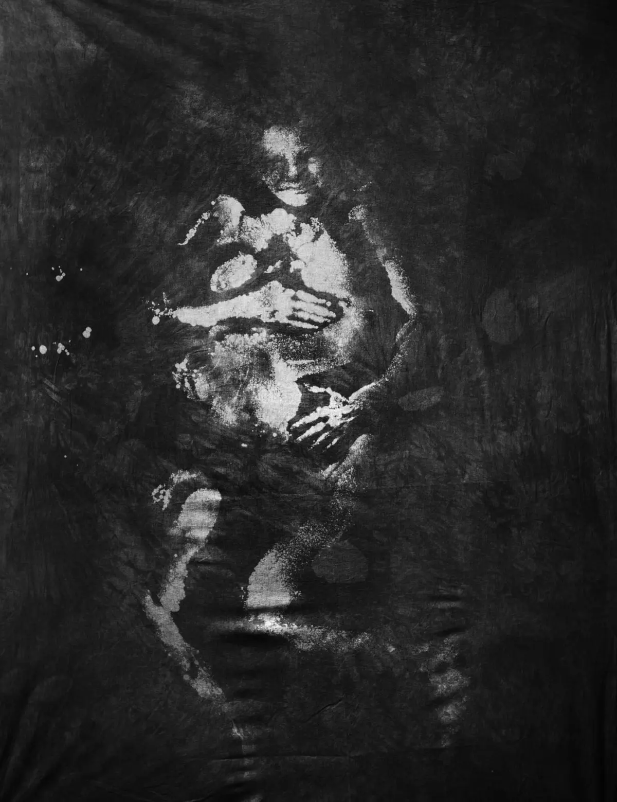 Abstract grayscale image of a human figure crouching, arms crossed over chest, against a dark textured background.