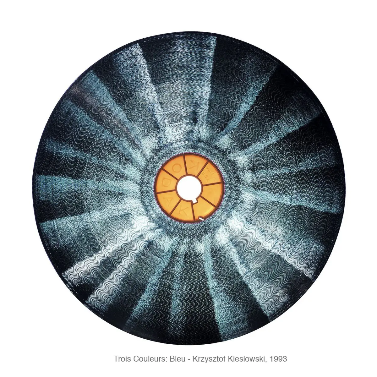 Large circular disc with teal blue radial pattern and an orange central hub against a white background.