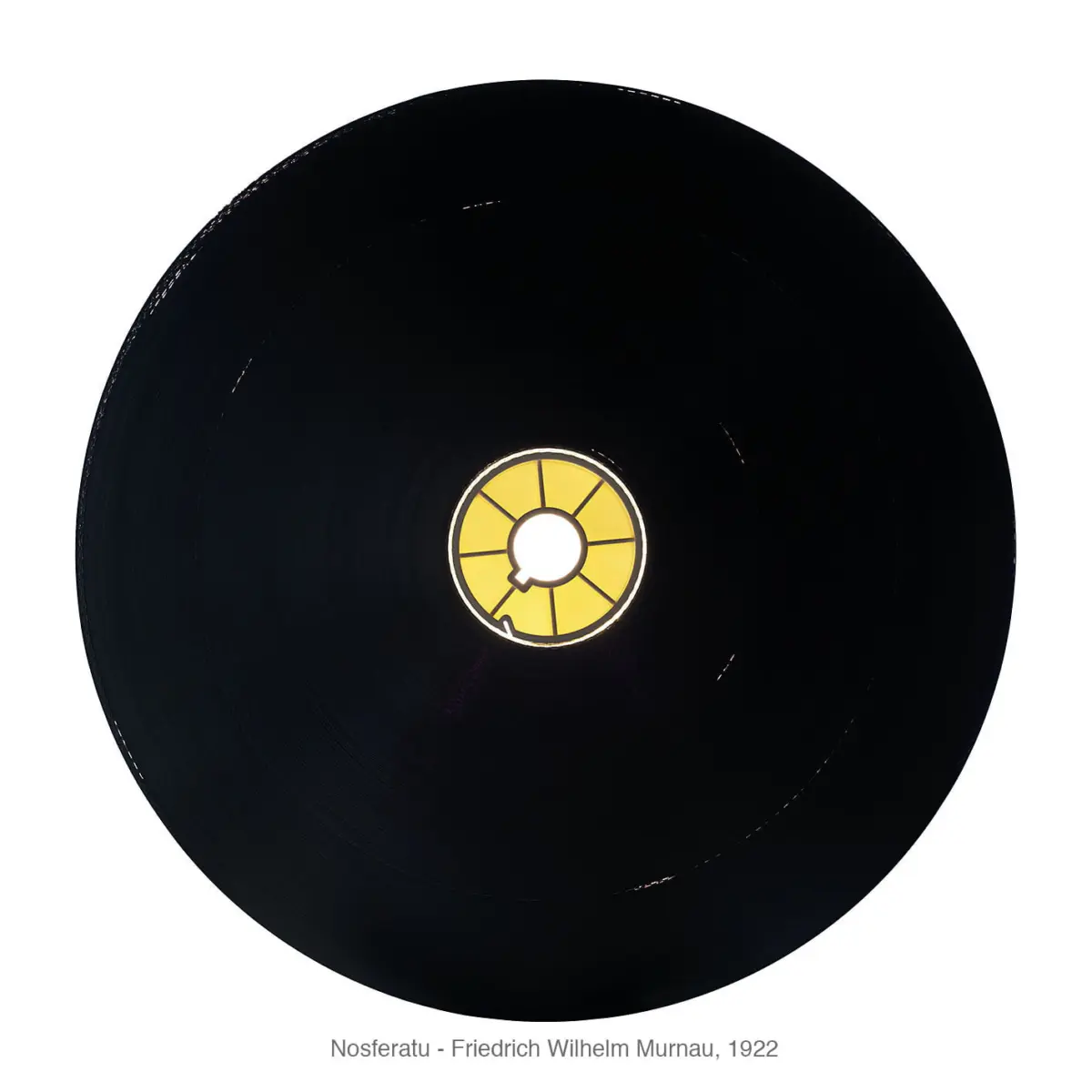 Top-down view of a black vinyl record with a yellow center label.