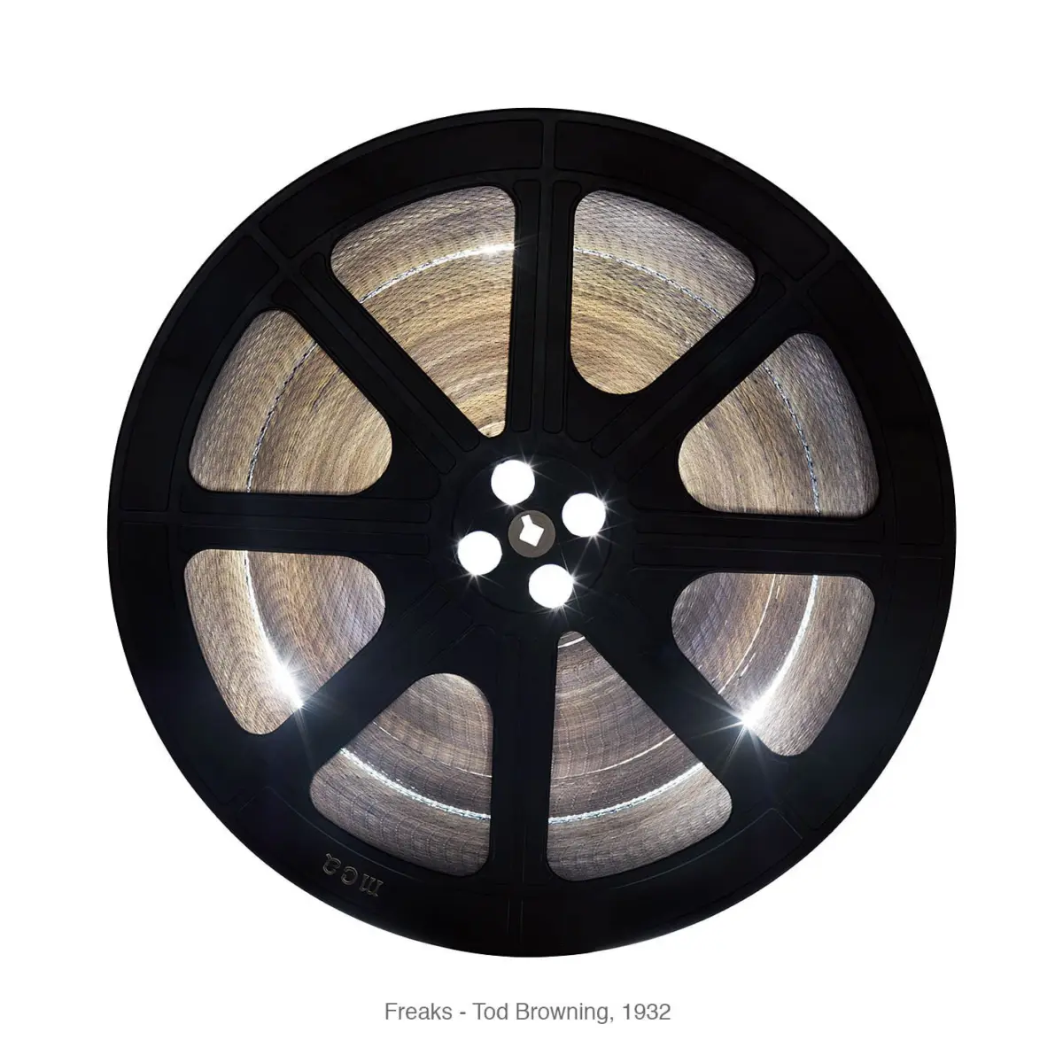 Black film reel with wound silver film, viewed from the front; circular hub with spokes.