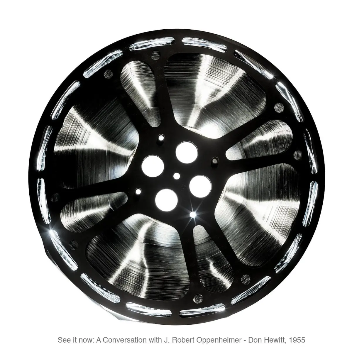 Close-up of a multi-spoke aluminum alloy wheel rim with a brushed metal finish against a white background.