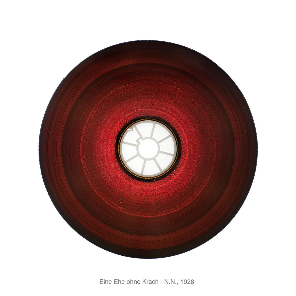 Top-down view of a red circular lampshade with a white, spoked center.