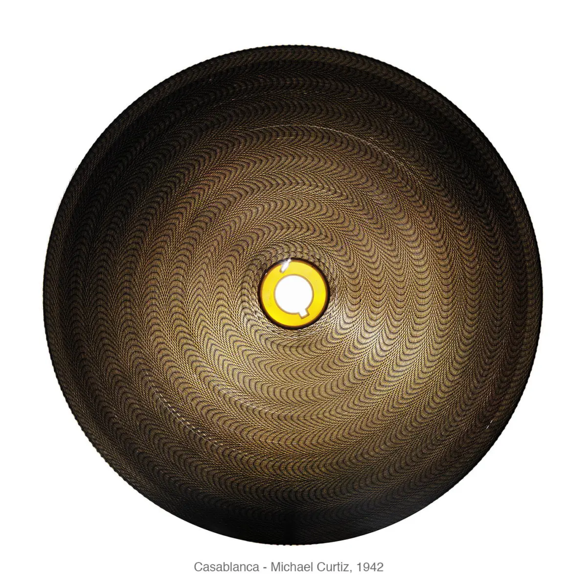 Close-up of a round textured disc with a spiraled pattern and a yellow ring around a white central opening.