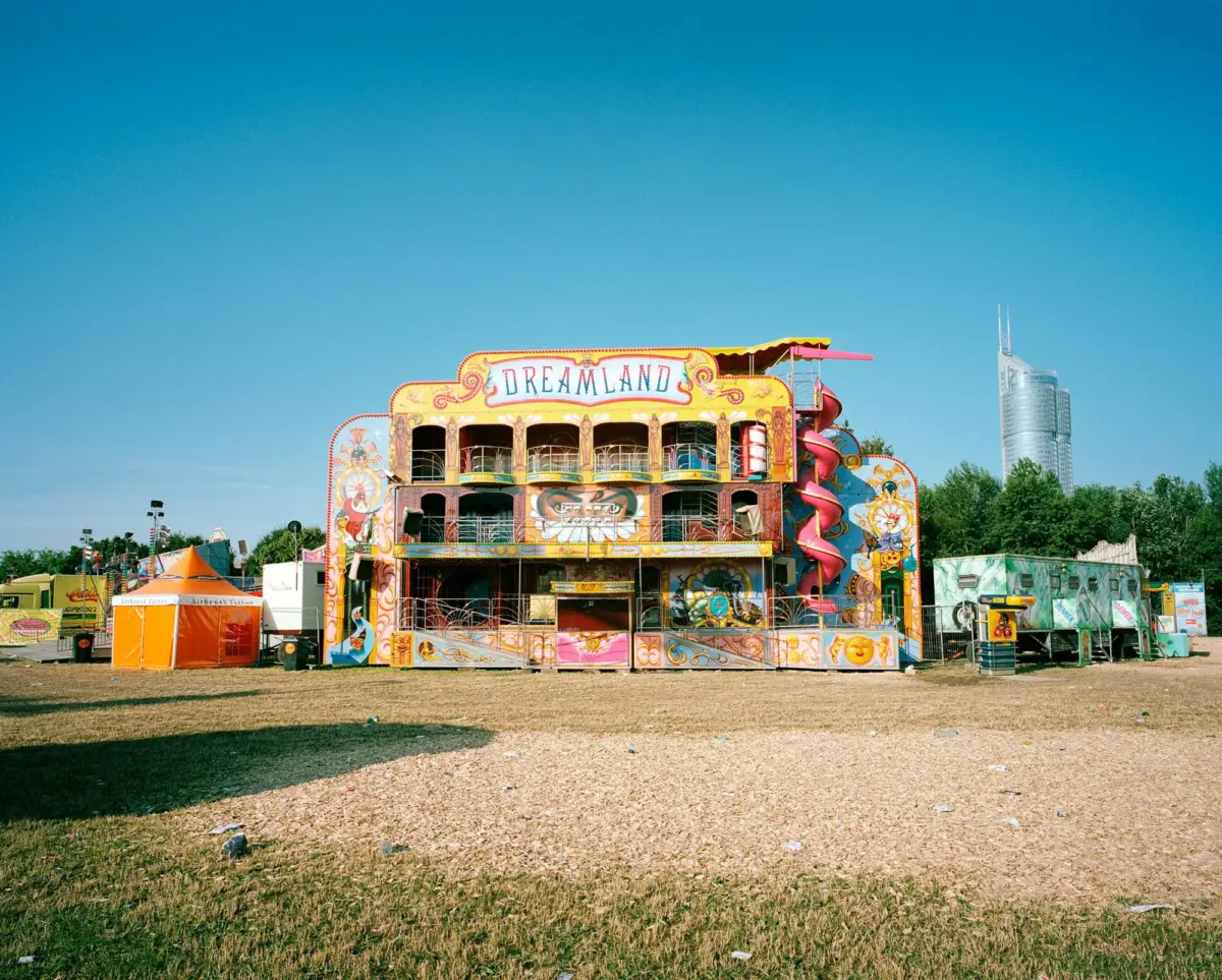 Dreamland carnival ride with ornate facade and pink spiral slide at a sunny fairground.