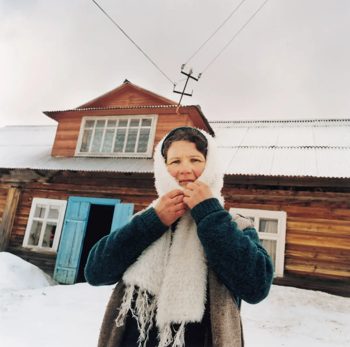 The wife of the mayor of Dzembronja in front of her house